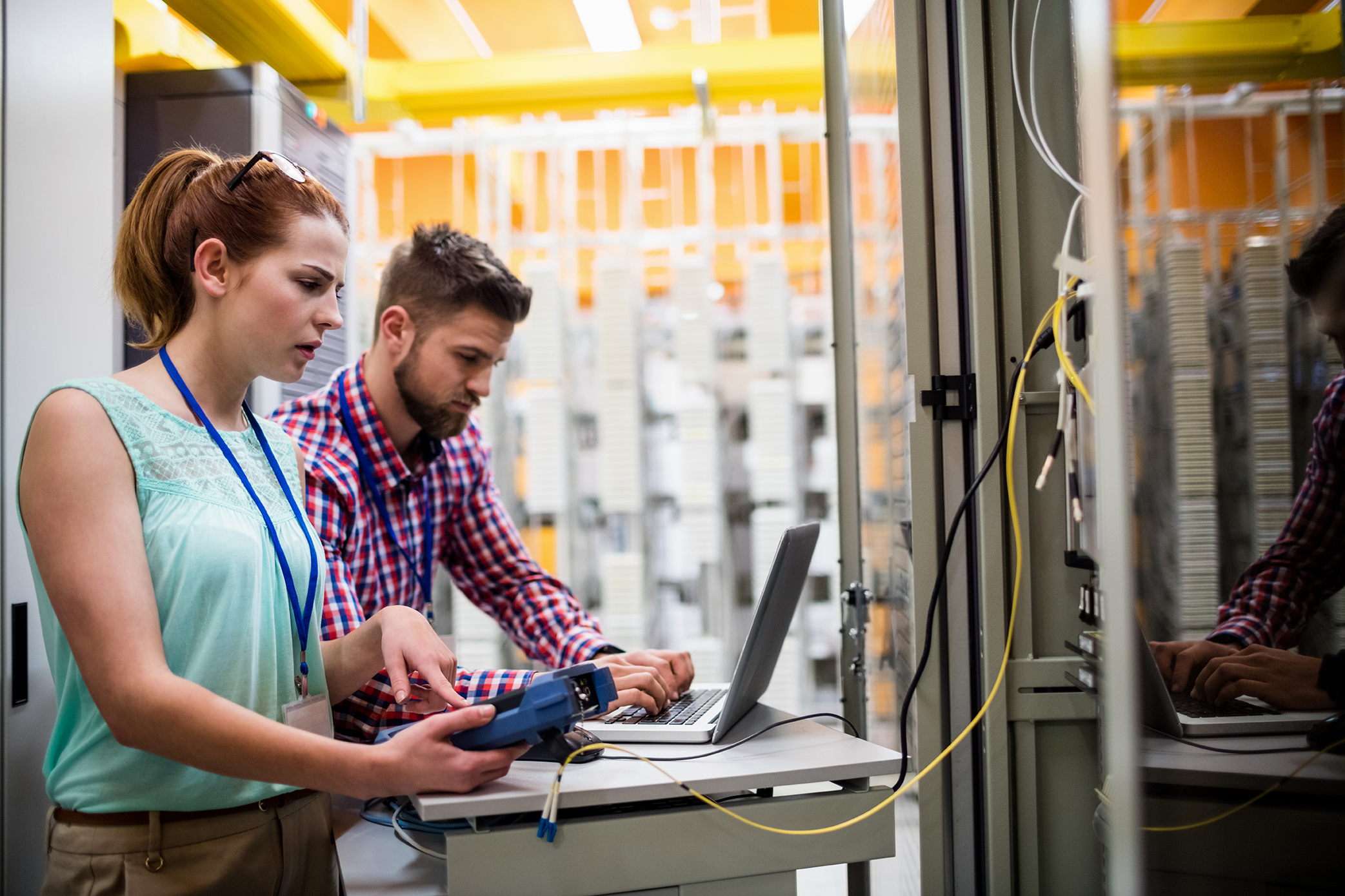 Technicians using laptop while analyzing server